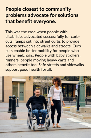 A man using a wheelchair navigates a sidewalk using a curb-cut